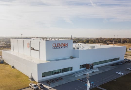 A large modern white square building with the Clemson University logo is a newly constructed research facility.