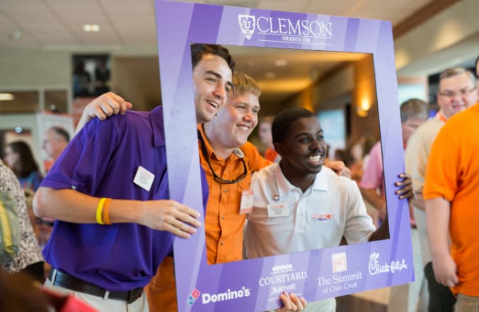 Two male orientation ambassadors pose with one of the new Clemson students in their group during Orientation.