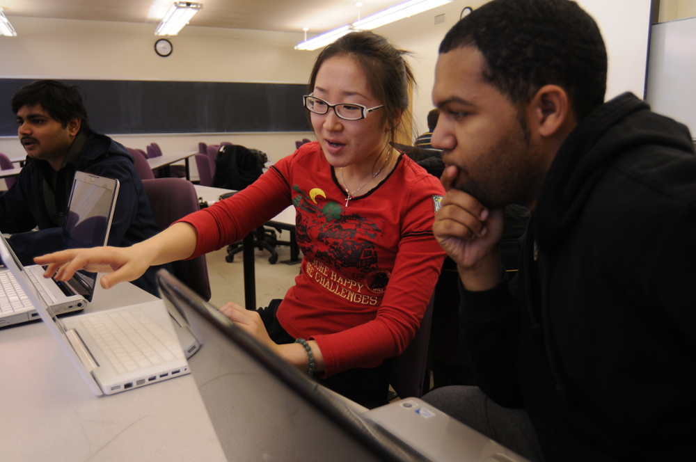 Students examining information on laptop