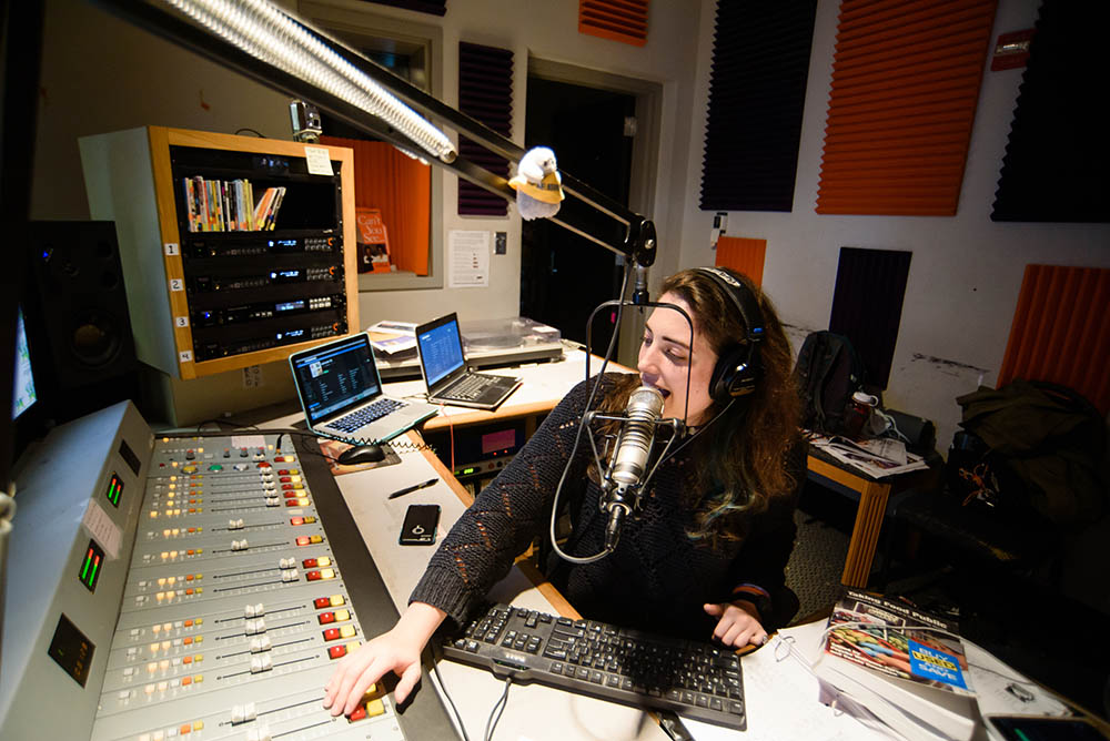 Woman in a radio station speaking into a microphone