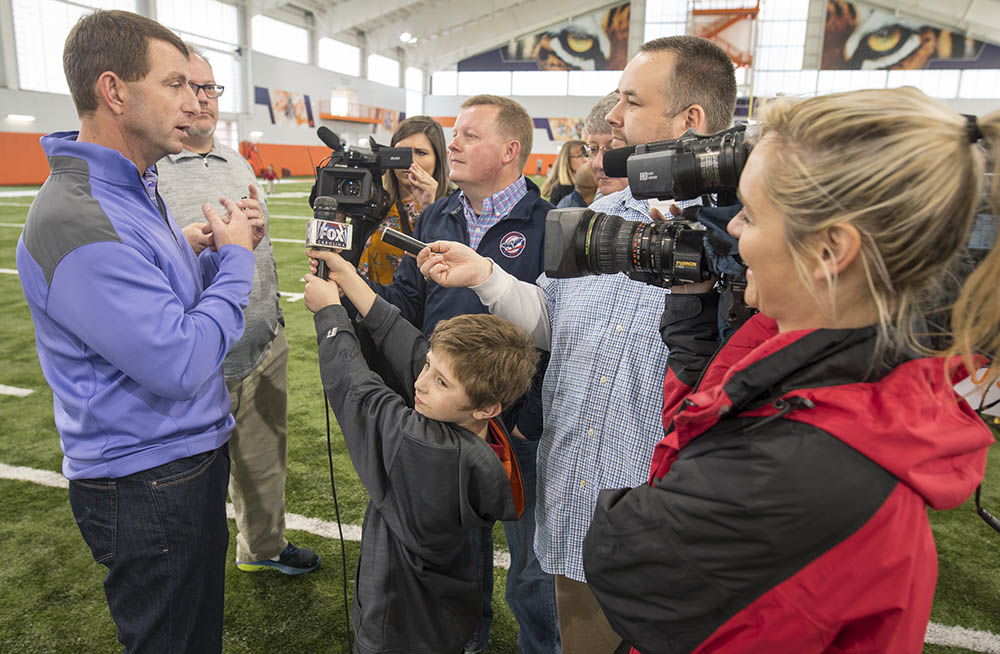 Several members of the media interviewing Clemson Football Head Coach Dabo Sweeny