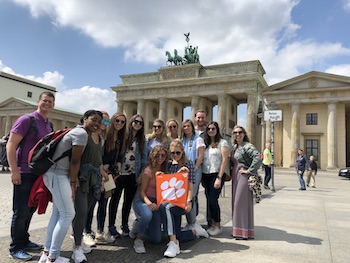 Clemson students standing in front of the iconic Brandenburg Gate which stands near the national parliament building in Berlin.