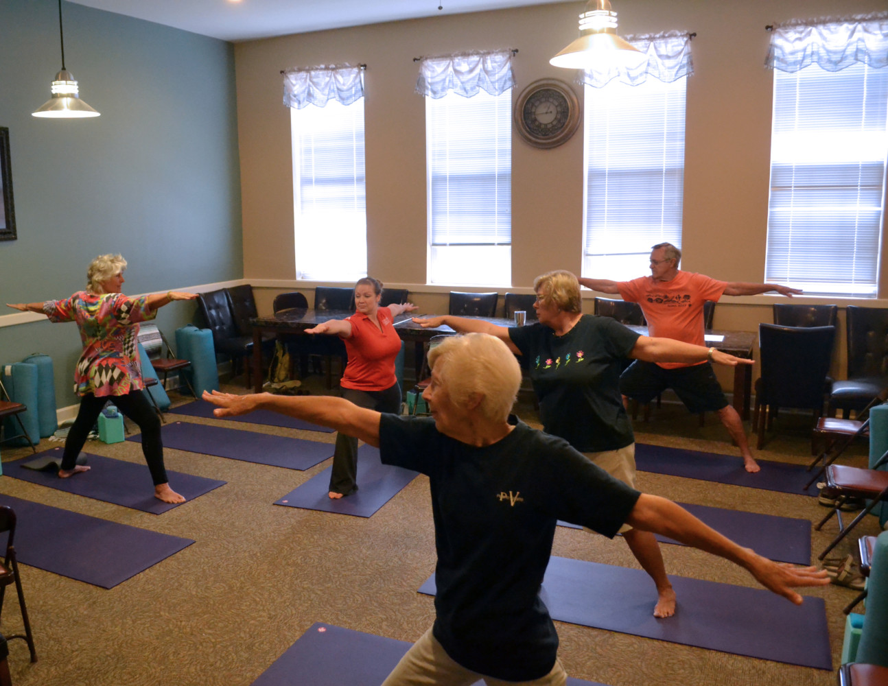 Picture of seniors doing yoga in a classroom.
