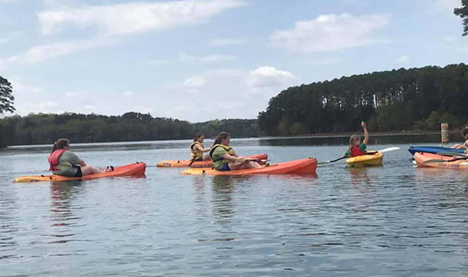 Finding Your Voice campers in kayaks during the 2019 camp. 