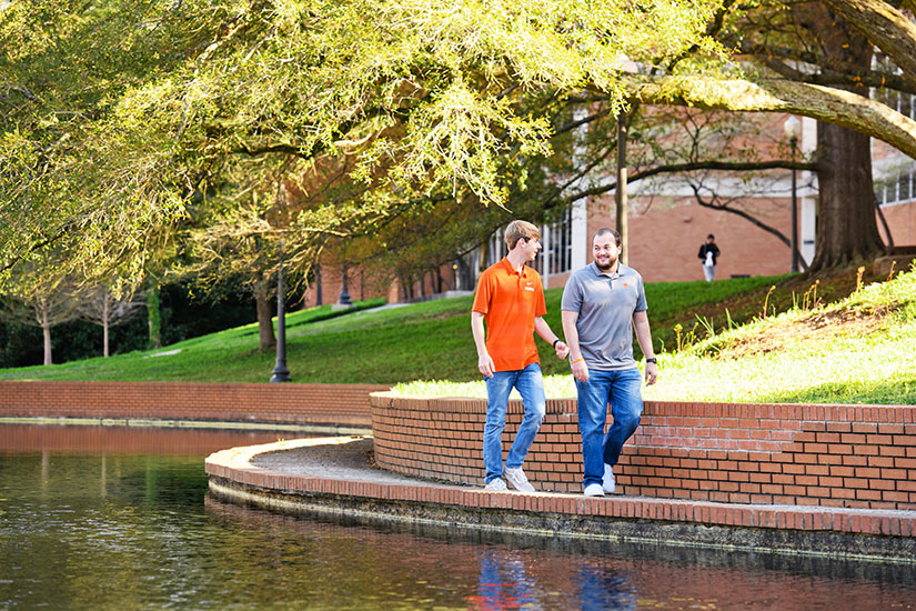Students walking around campus pond