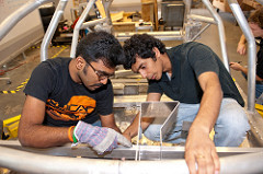Two students working inside of test car.