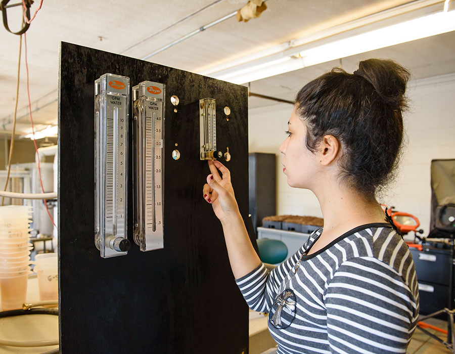female undergraduate student in lab with test equipment.