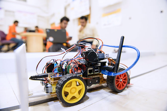 Faculty and graduate student working on autonomous car technology.