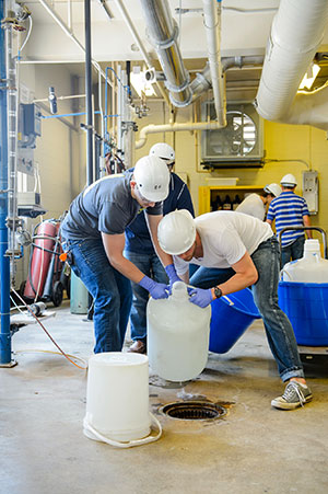 Students in unit ops lab lifting jug.