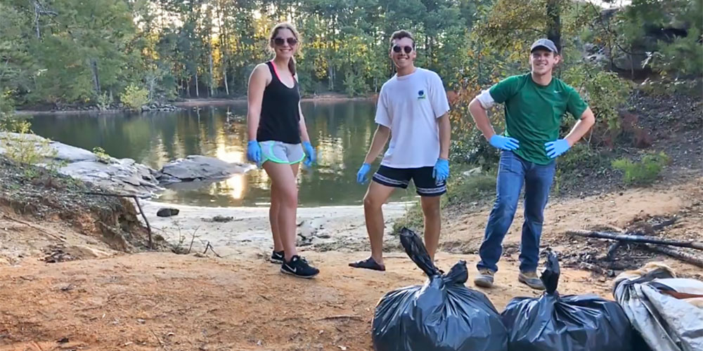 2 male and 1 female members take part in water clean up