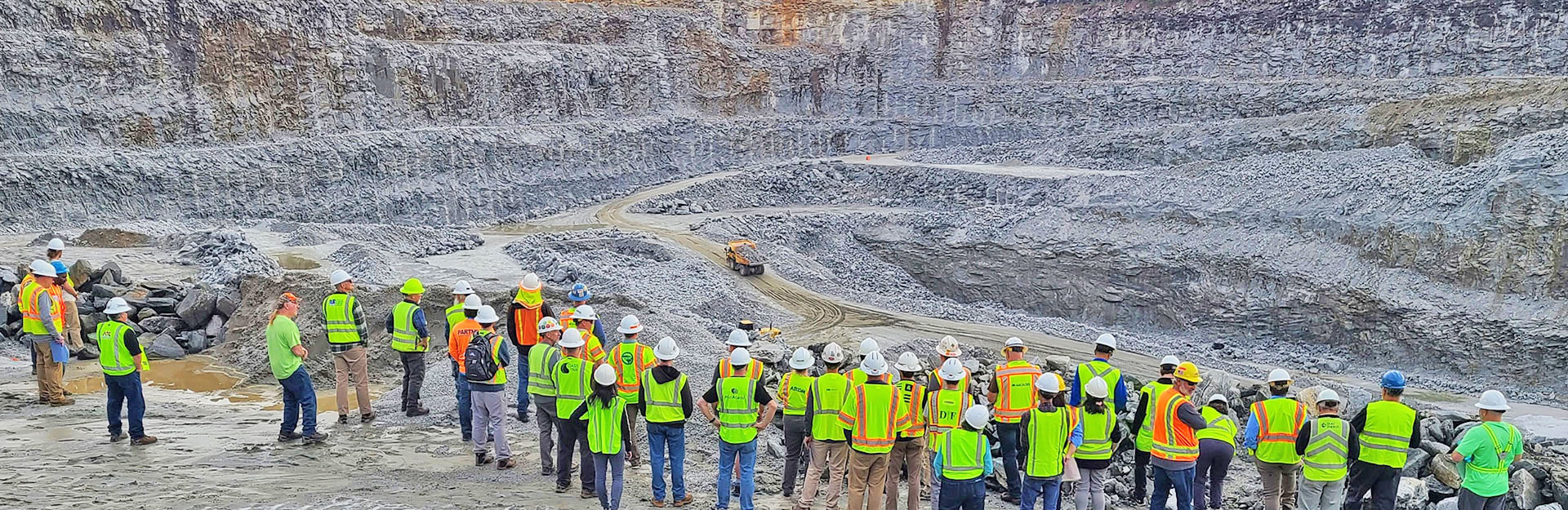View of quarry with men in high-visibility vests looking on