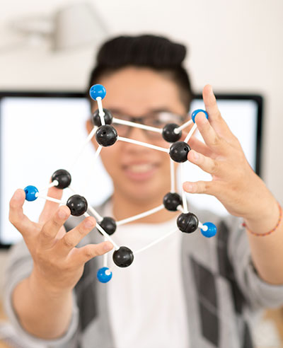 Student holding up molecular model