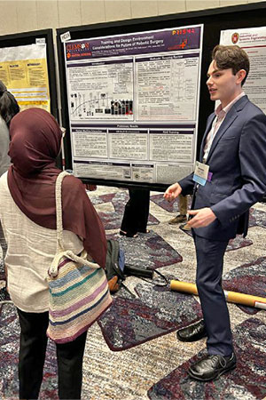 Student at HFS conference in front of poster.