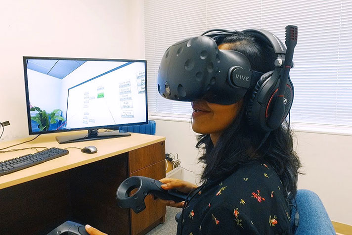 Graduate student using VR technology for a fully immersive experience.