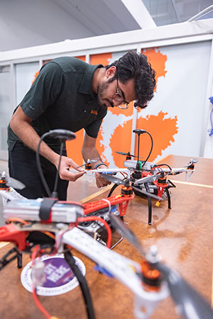 Male student working with drone model.