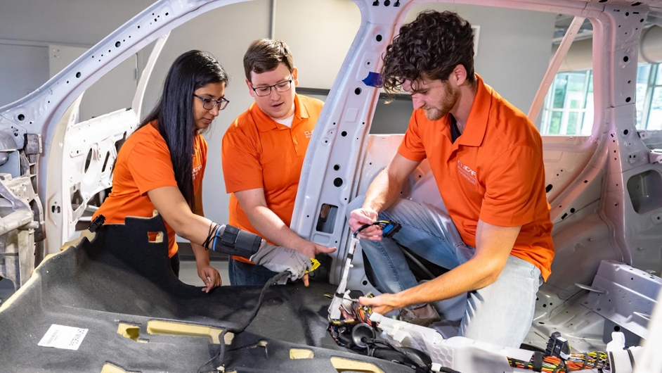 three students in the automotive engineering program working on project together