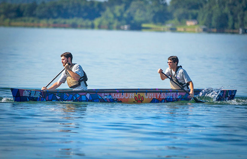 Two students in a concrete canoe on the lake.