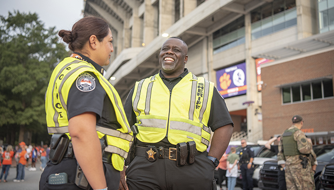 Two officers laughing with each other outside of the Doug Kingsomore Stadium 