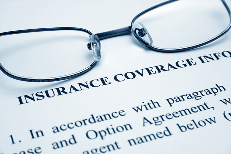 glasses placed on top of insurace coverage document