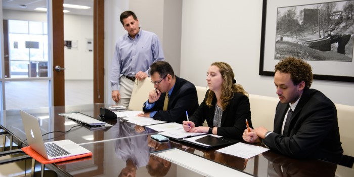 A group of employees looking at a laptop during a meeting