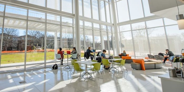 Students on laptops in the lobby of the Watt Center
