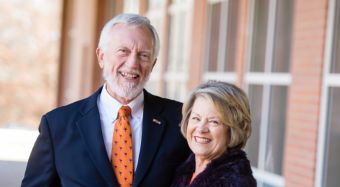 Tripp and Anne Jones smiling in front of a building