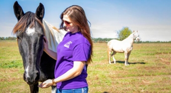 Lizz Sampson petting a horse