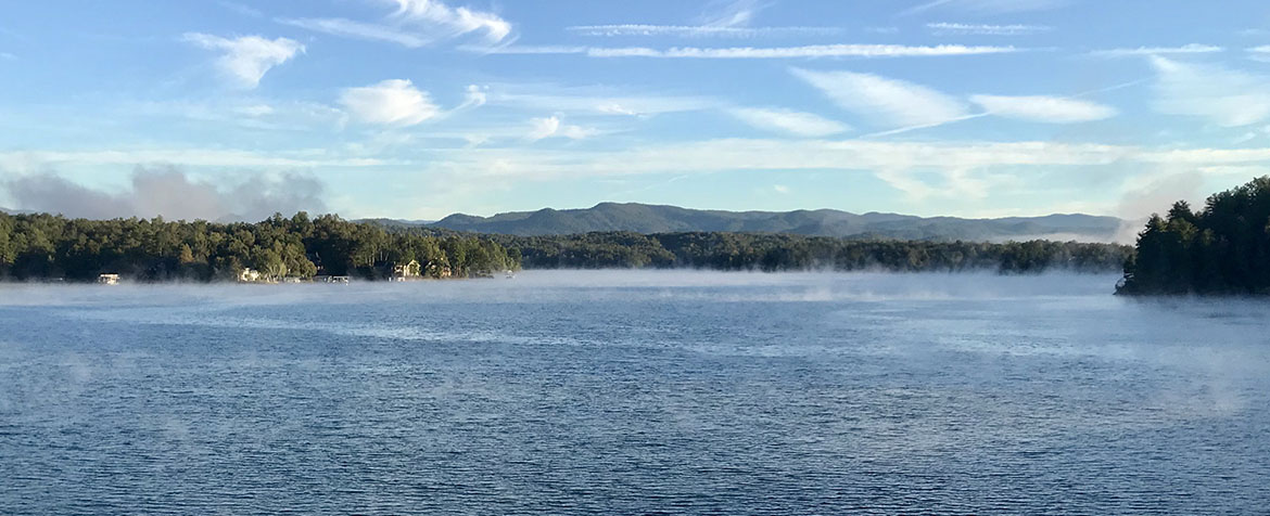 sunny day at lake keowee with fog rising from water