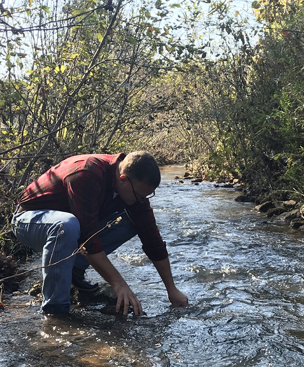 Volunteer collects a water quality sample