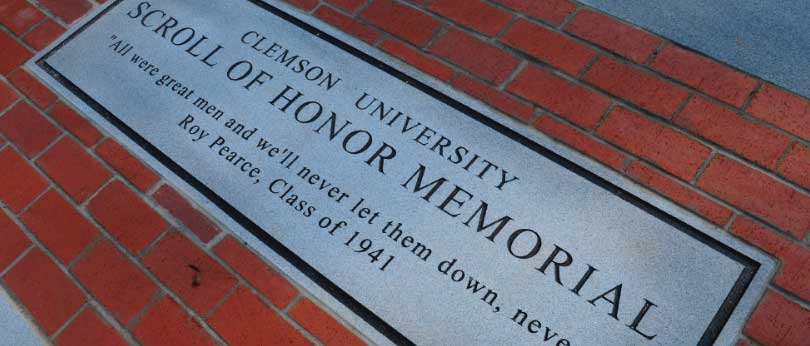 A concrete block is inscribed with words dedicating the Clemson University Scroll of Honor Memorial.