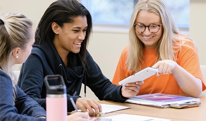 New Clemson students sit together at a classroom table.