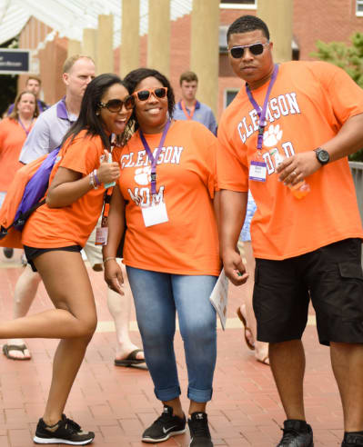 A student smiles with her parents during a Summer Orientation session.