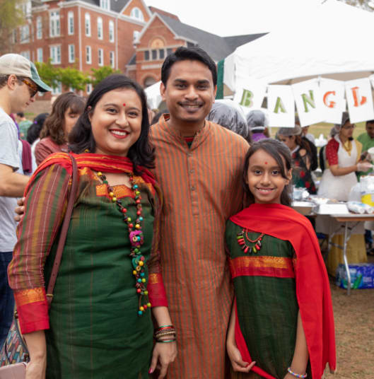 A multicultural family wearing traditional clothes pose during the international festival.