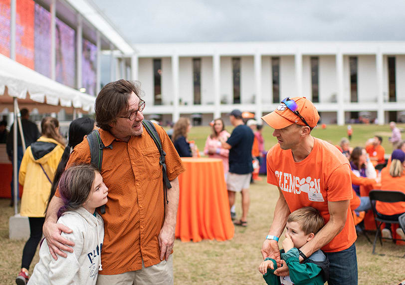 Clemson faculty and their children interact at a gathering behind Cooper Library.
