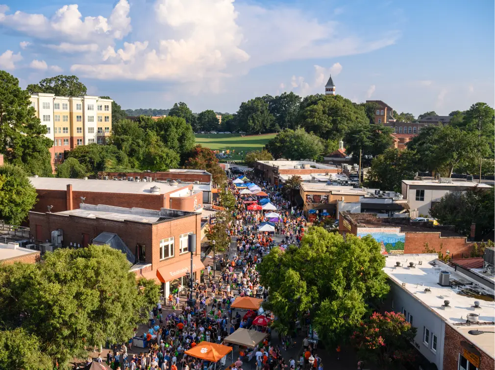 An aerial view of downtown Clemson packed with students during the welcome back festival, with bowman feild visible in the background