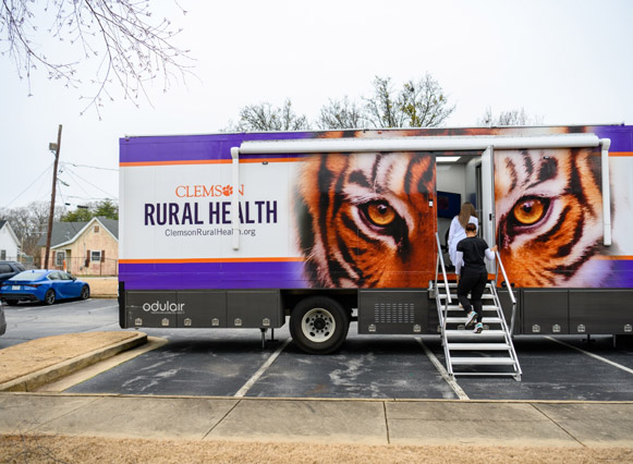 Two people entering the Clemson Rural Health mobile clinic.