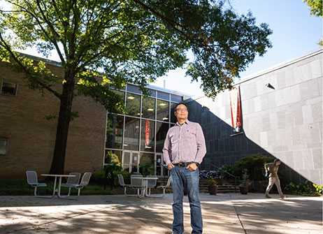 Joe poses in front of a building on campus.