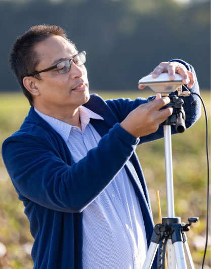 Joe adjusts a sensor out in a cotton field.