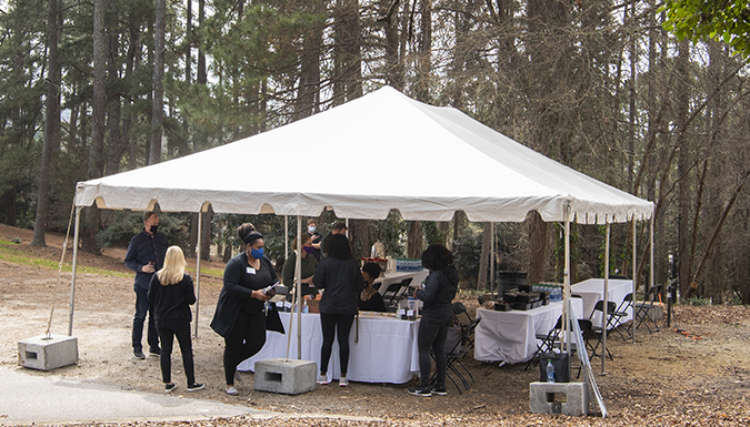 Volunteers gather at a tent for cemetery tours.