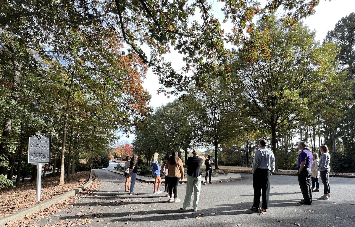 A group starts the cemetery tour at the entrance.