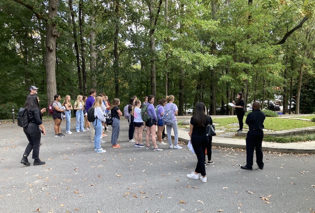 A student tour guide leads a group on the tour.