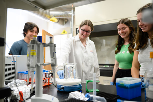 A Creative Inquiry watches a reaction in a beaker in a university lab