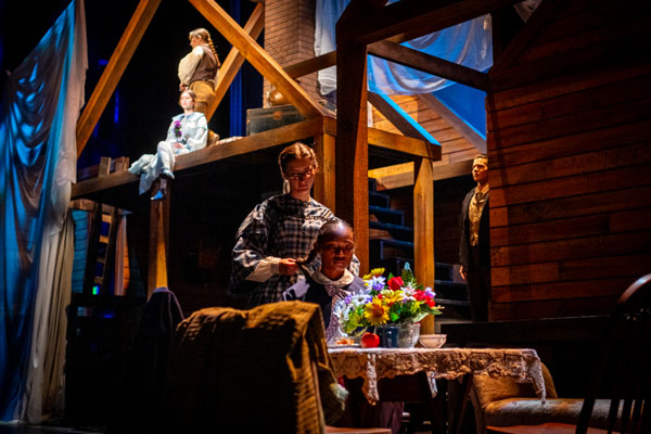 student actors place on stage during a dress rehearsal of Little Women
