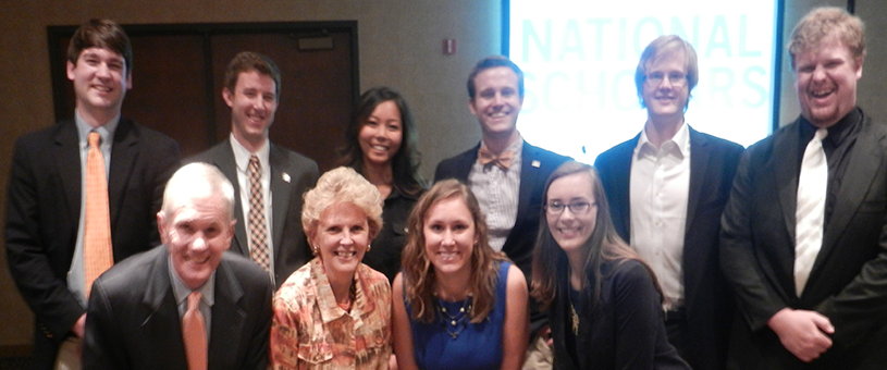 A group of scholars posing with President and Mrs. Barker