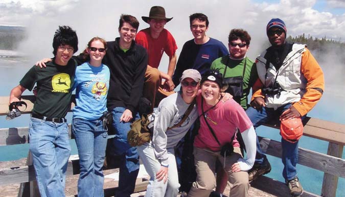 A group of scholars posing together overlooking a scenic outlook.