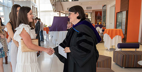 New member shakes the hand of a professor.