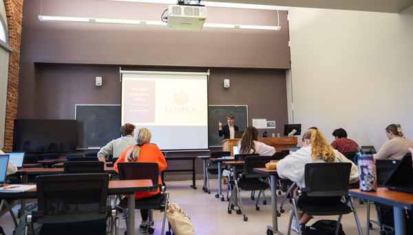 A classroom of students listen to a philosophy lecture from a male professor at the front of the class