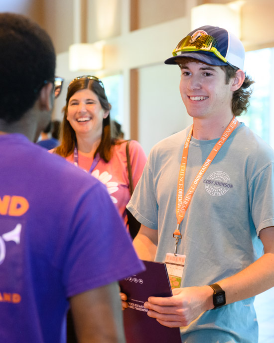 a male freshman student and parent speaks with an orientation ambassador