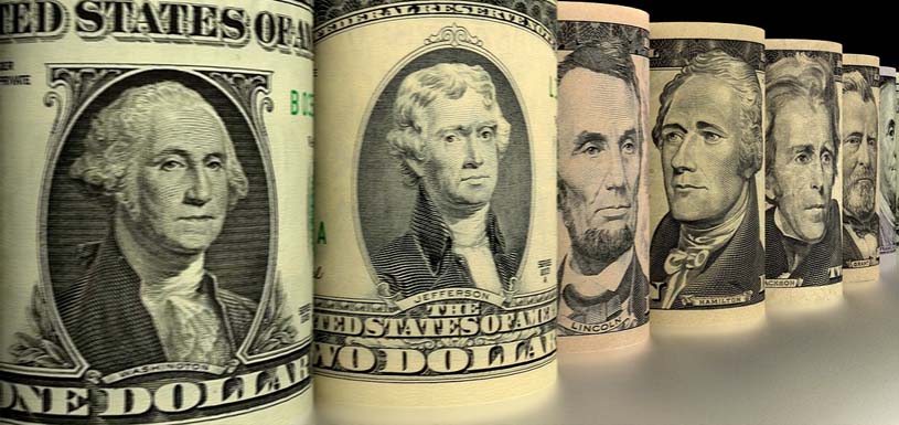 Several dollar bills arranged to show presidents prominently