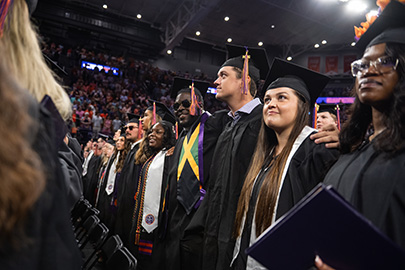 Several students wearing cap and gowns at the graduation ceremony.